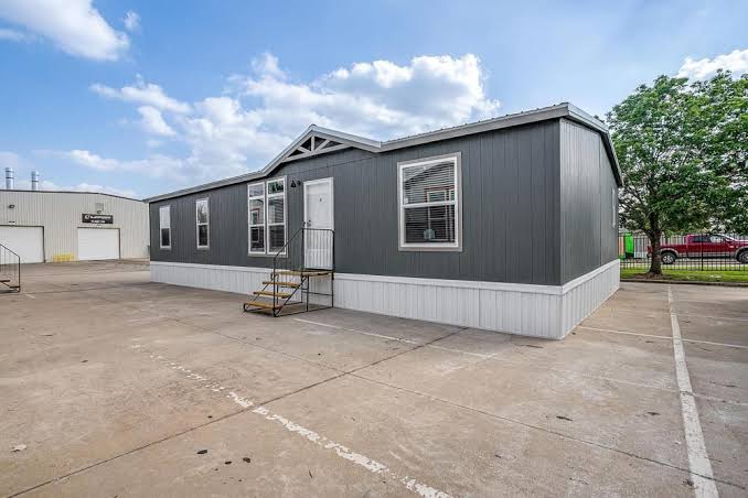 Modern manufactured home with gray siding and white trim.